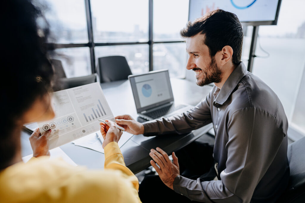Ein Mitarbeiter analysiert einen Finanzbericht, überprüft Diagramme und Zahlen in einem modernen Büro.