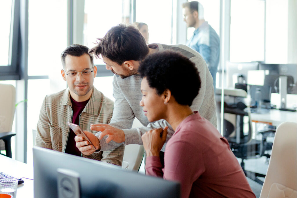 Experten arbeiten gemeinsam in einem modernen Co-Working-Space und tauschen kreative Ideen aus.